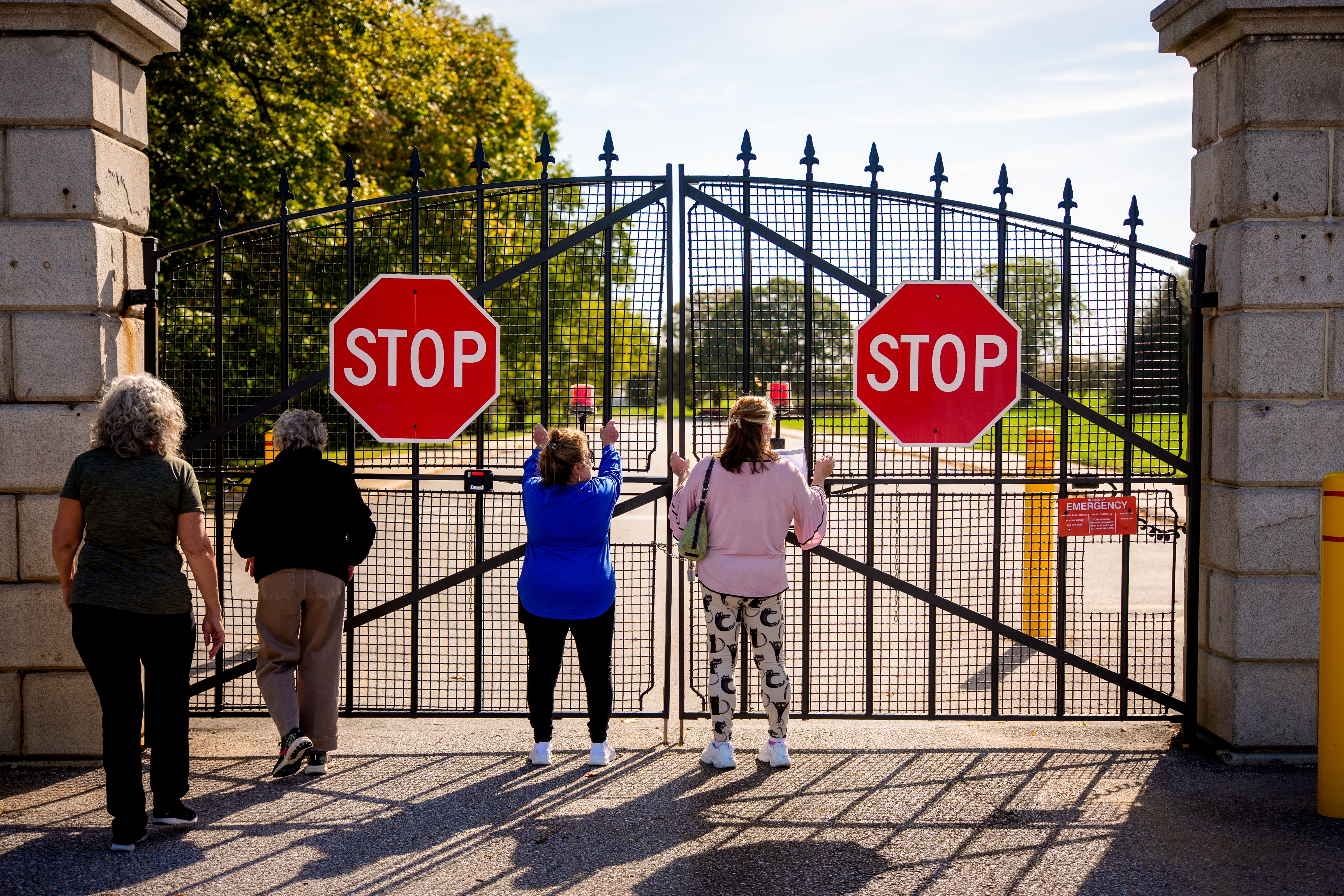A group of friends and family traveling on a road trip, Harriett Green of Milford, N.J., Eveyn Hauck of Bangor, Pa., Colleen Abahazy of Easton, Pa., and Sharon Reuss of Easton, Pa., look through the locked gate to Fort McHenry National Monument and Historic Shrine on Oct. 3 in Baltimore, Md. The fort is closed due to the government shutdown.